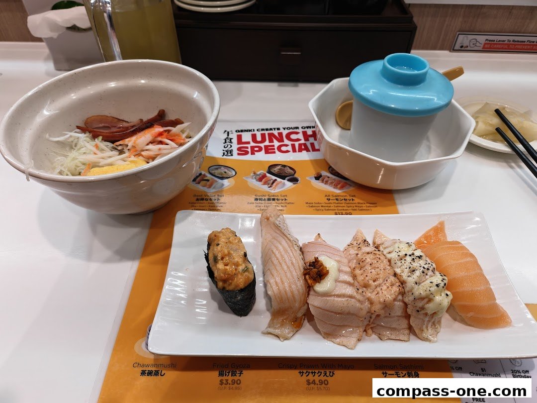 A table at Genki Sushi Compass One with various sushi dishes and a lunch special menu.