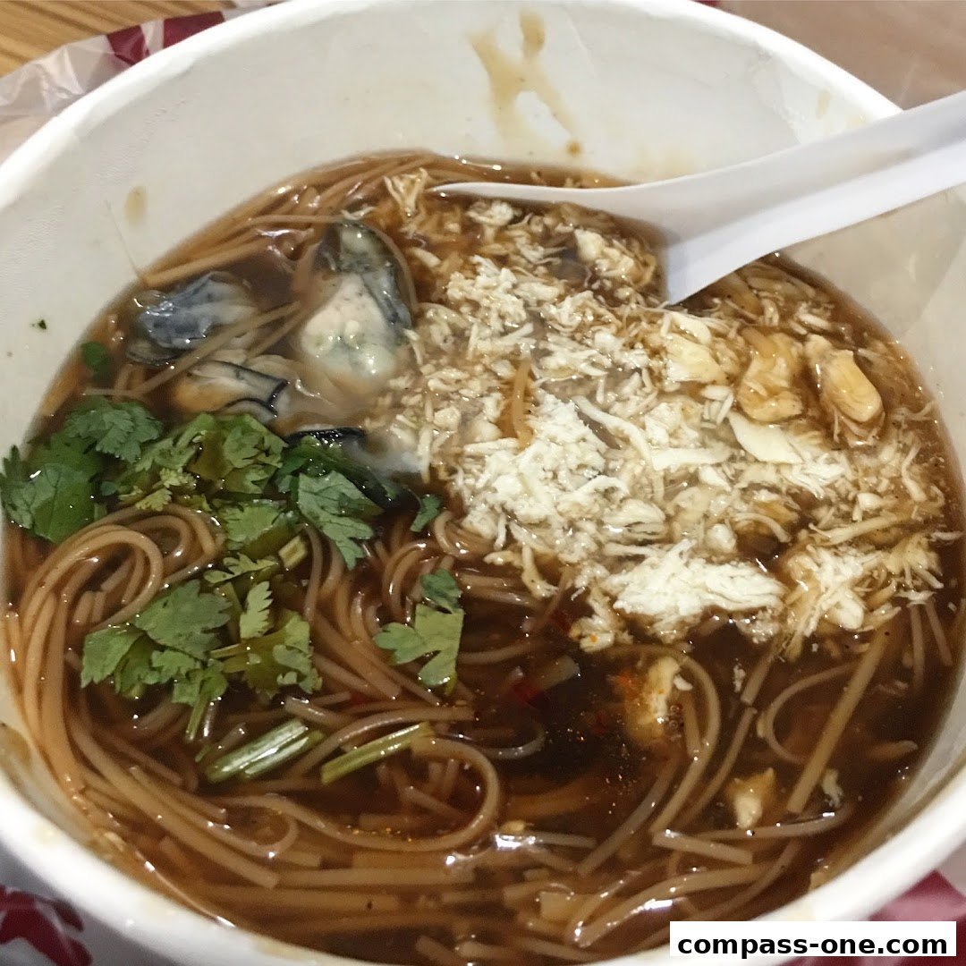 A close-up shot of a bowl of Taiwanese oyster vermicelli soup with cilantro.