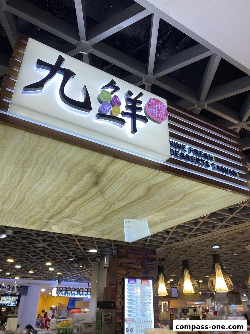 A brightly lit sign for Nine Fresh Desserts Taiwan with colorful candy-like graphics.