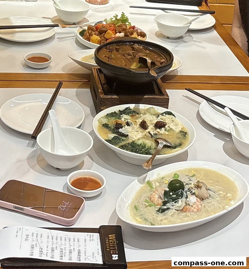 A table laden with various dishes, including a stew, stir-fried vegetables, and noodles, set for a meal.