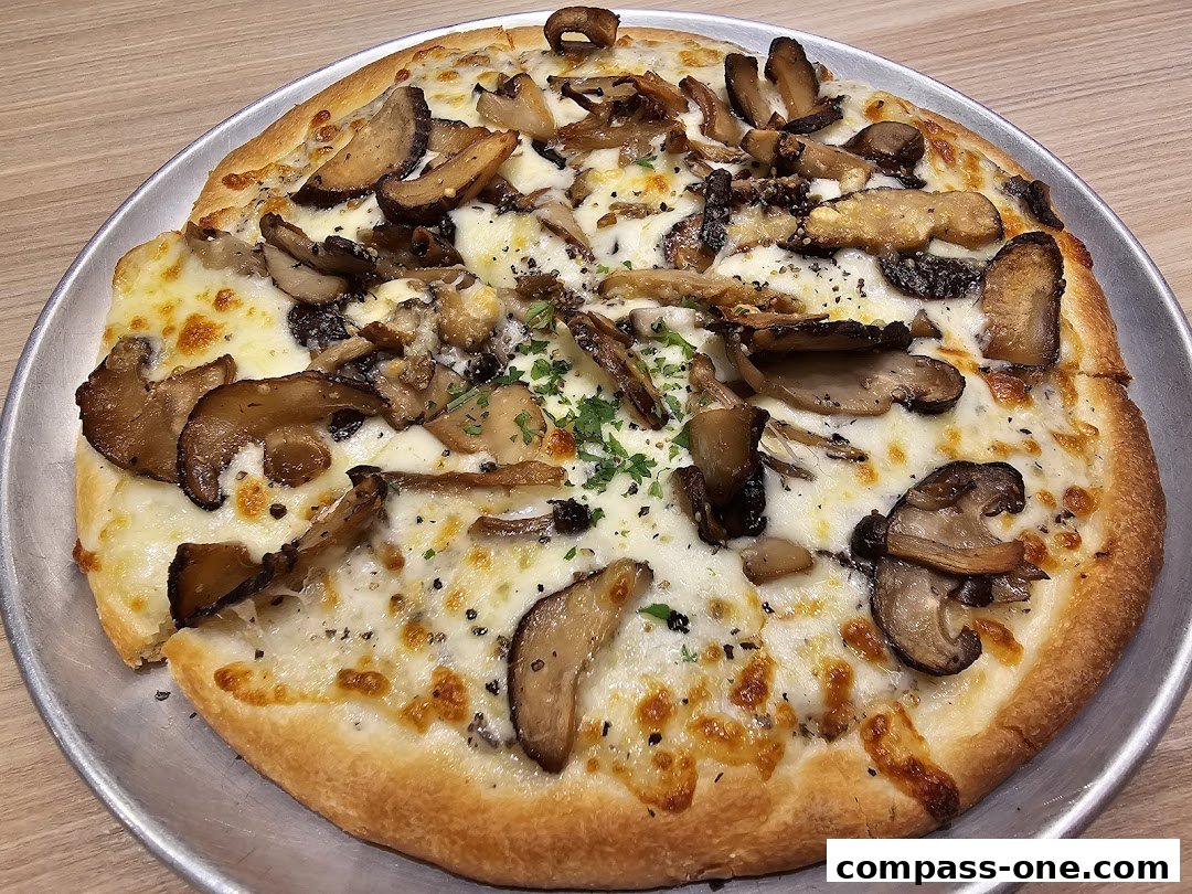 A delicious mushroom pizza with melted cheese and fresh herbs on a metal plate.