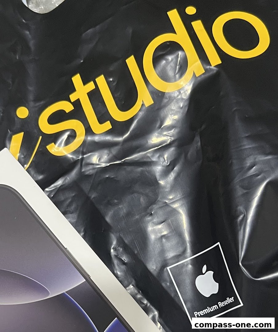 A black shopping bag with the yellow 'iStudio' logo and an Apple Premium Reseller sticker.