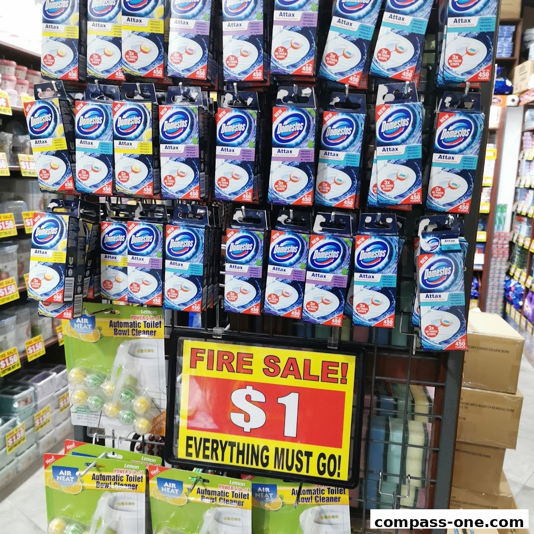 A display of cleaning products, including toilet bowl cleaners and Domestos Attax, with a prominent "Fire Sale! $1" sign.