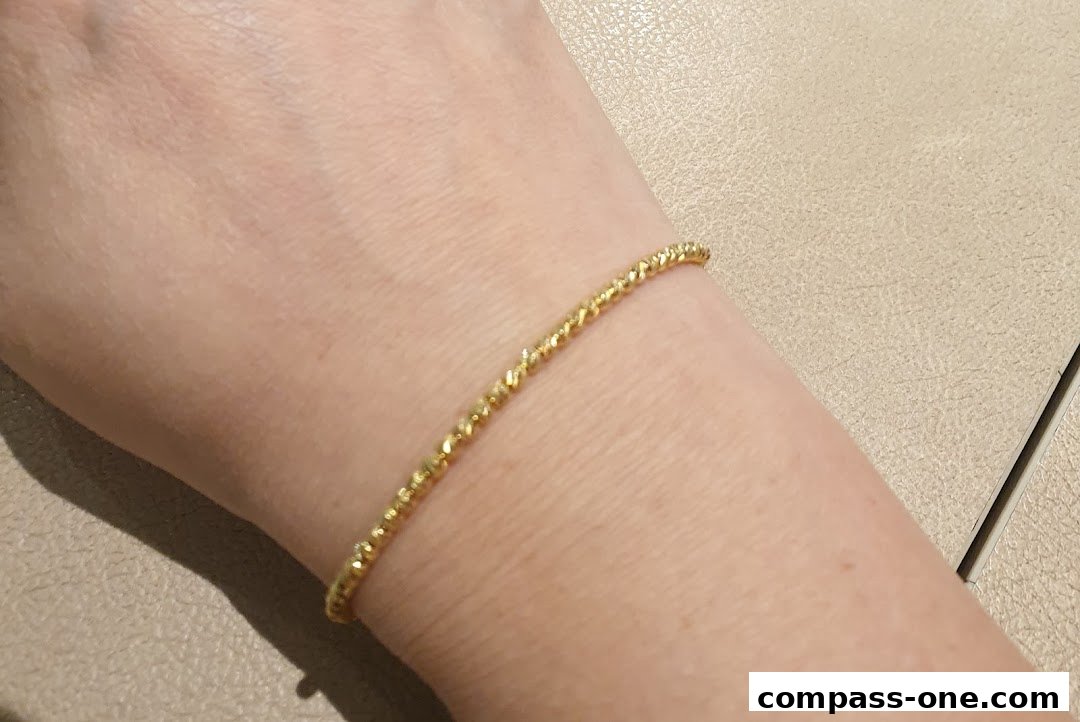 A close-up shot of a delicate gold bracelet on a person's wrist.