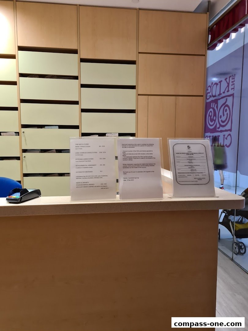 A reception counter at The Kids Clinic with informational pamphlets and a payment terminal.
