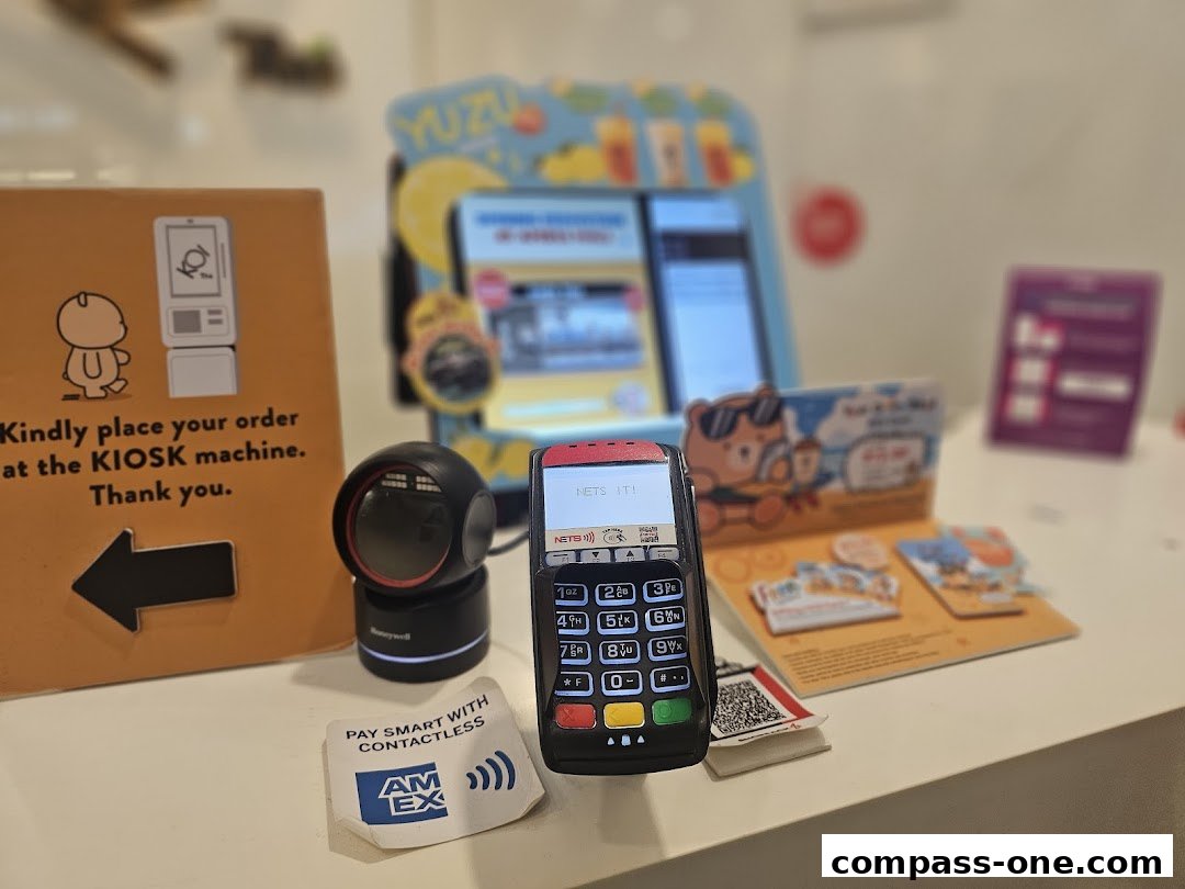 A counter display with a payment terminal, scanner, and ordering instructions.