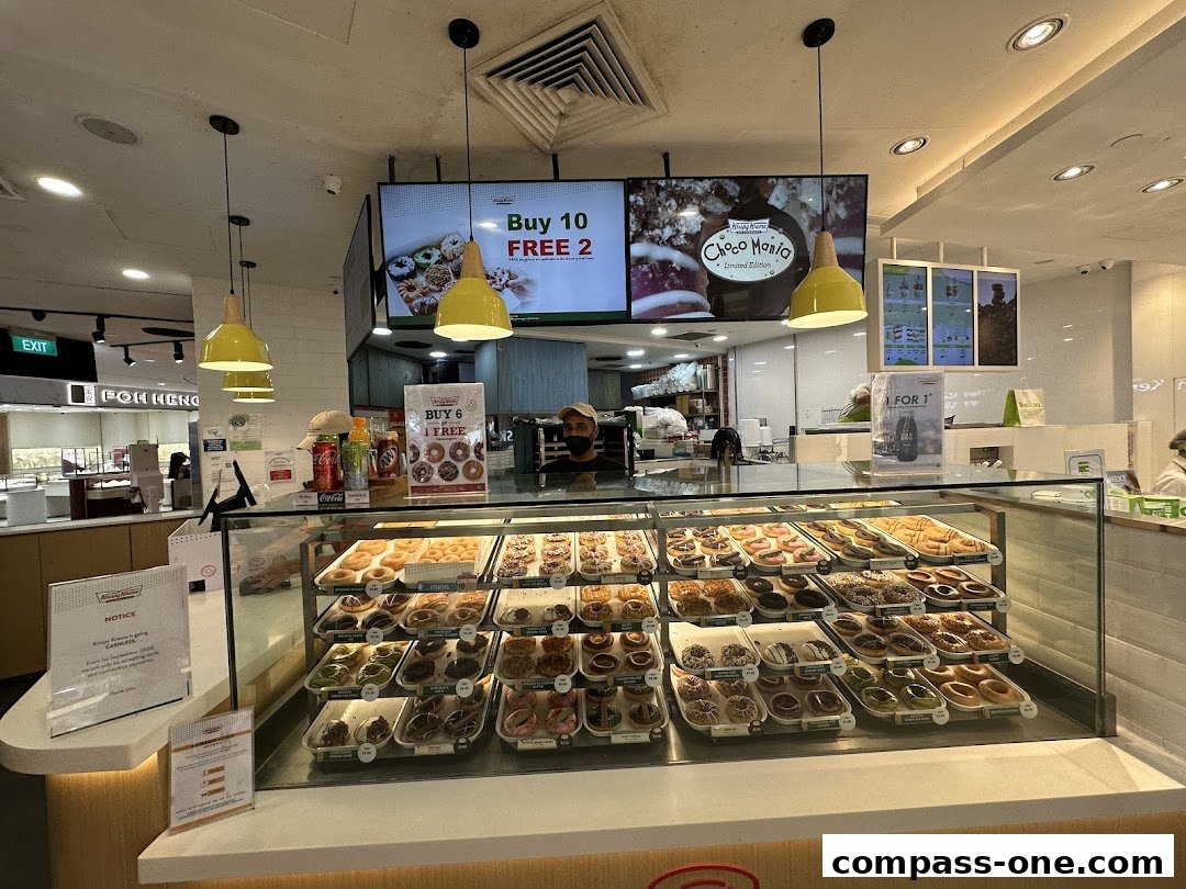 A display case filled with a variety of colorful donuts at Krispy Kreme.