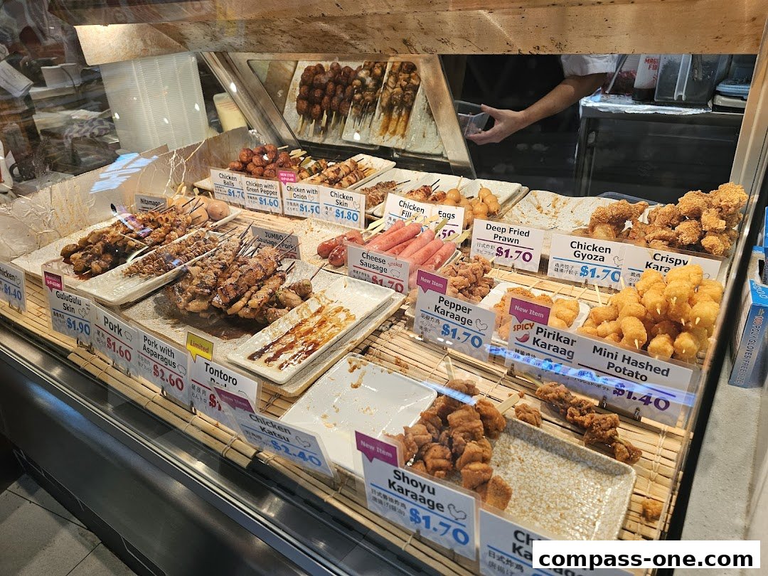 A display of various Japanese skewers and fried snacks with price labels.