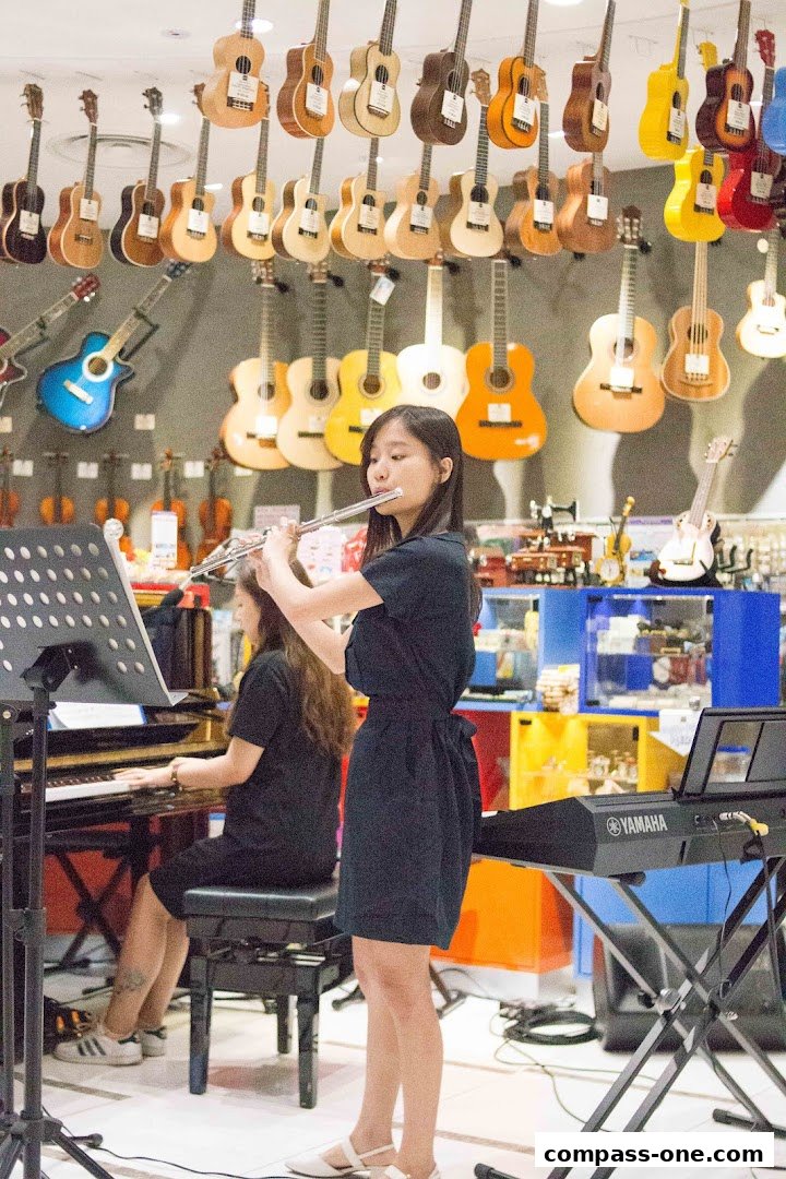 Two young women practice music in a store filled with guitars and keyboards.