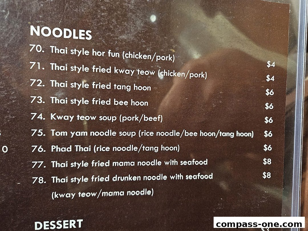 A close-up of a menu featuring various Thai noodle dishes with prices.
