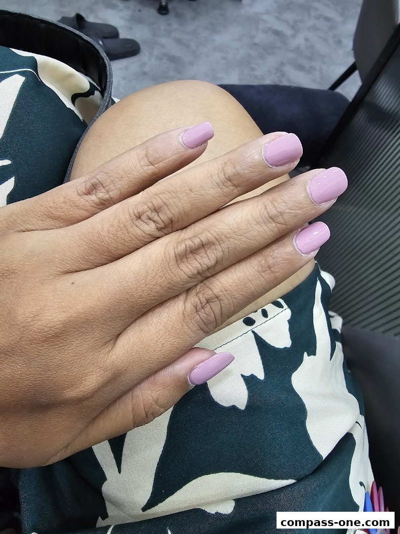 A close-up of a person's hand with neatly painted light purple nails.