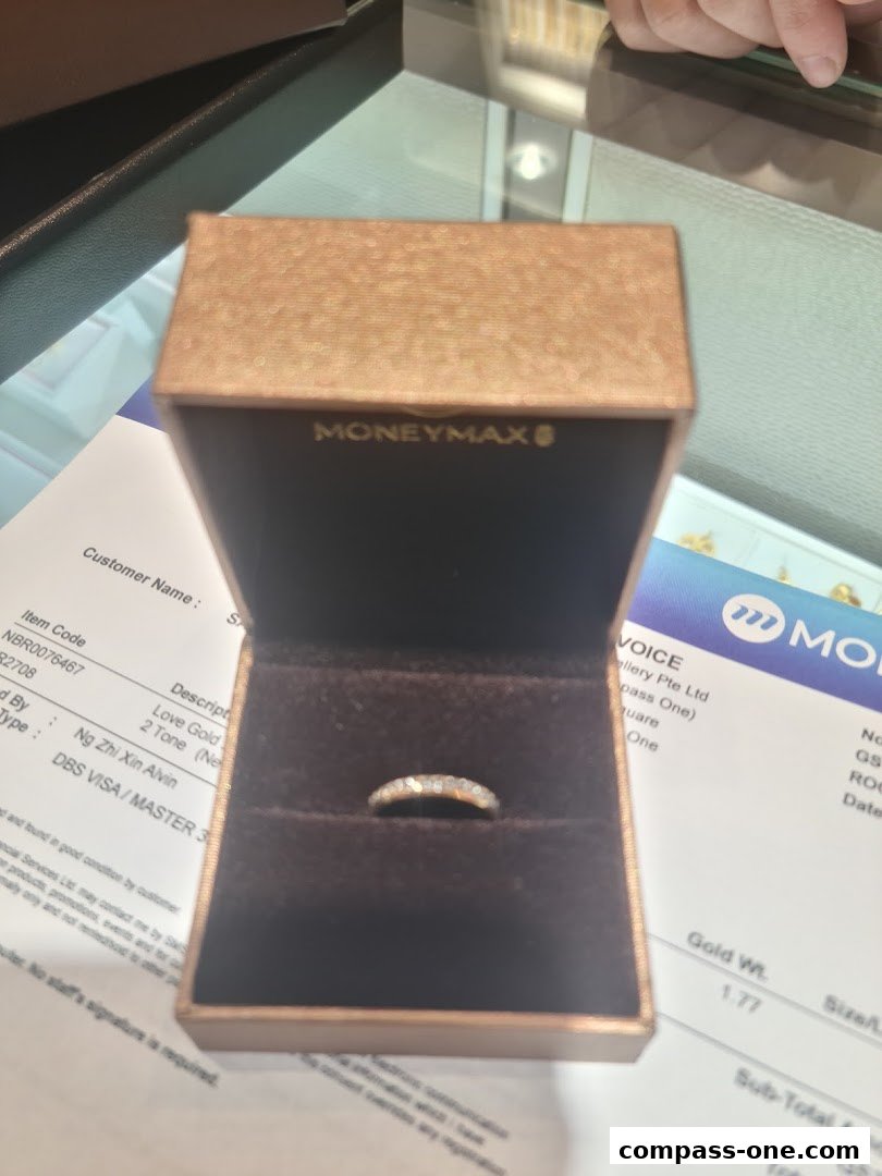 A diamond ring in a MoneyMax jewelry box with a receipt in the background.