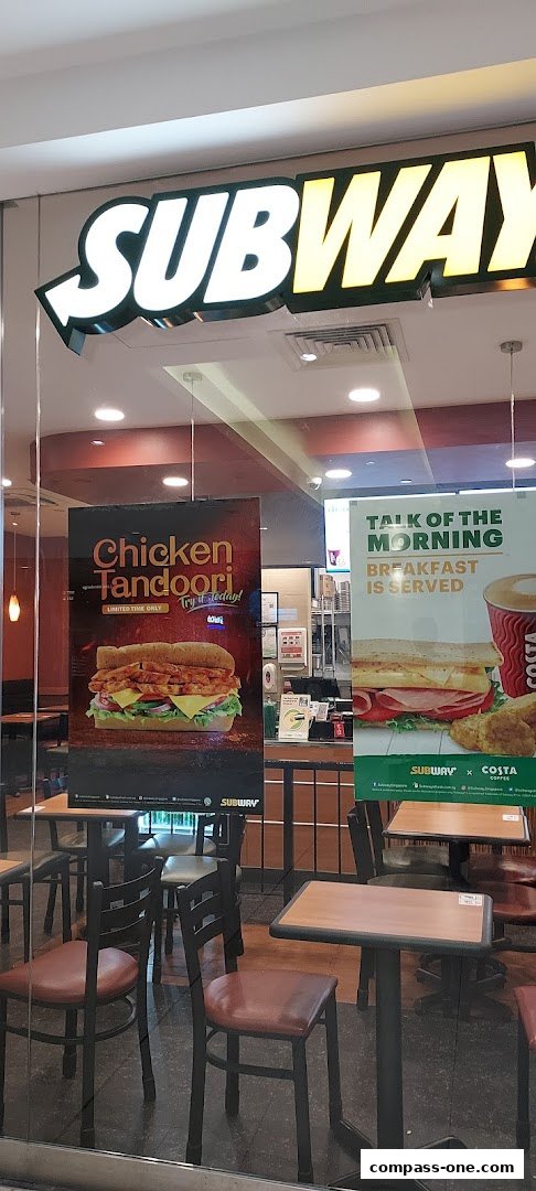 The exterior of a Subway restaurant with promotional posters for Chicken Tandoori and breakfast.