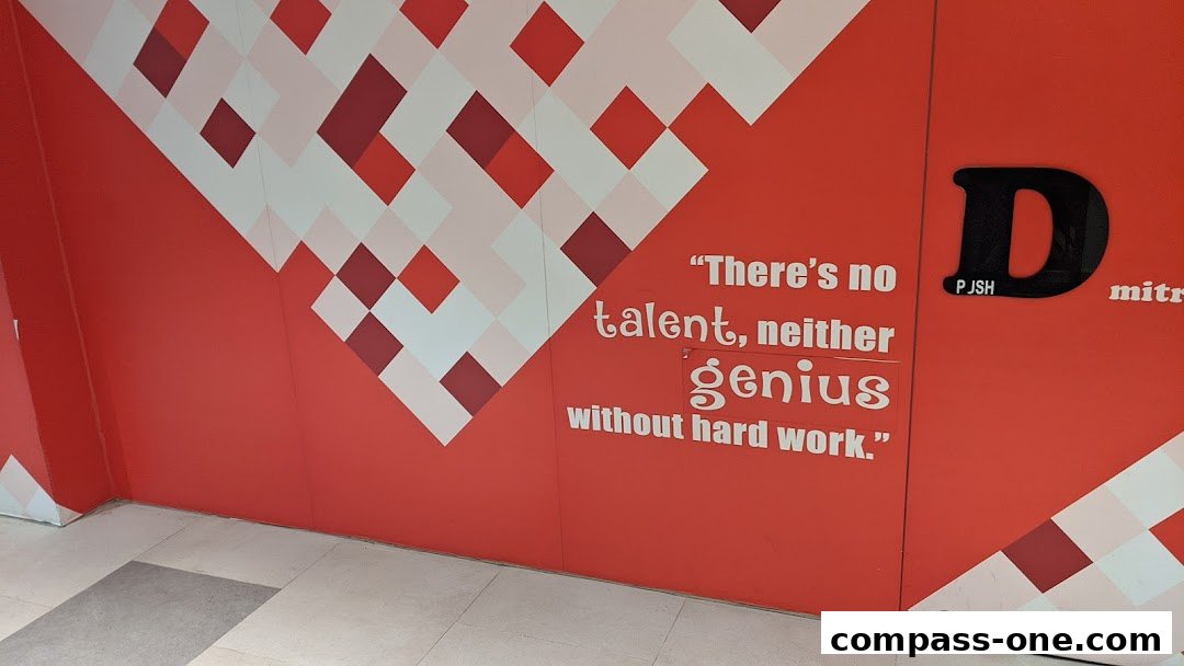 A red wall with a geometric pattern and an inspirational quote about hard work.