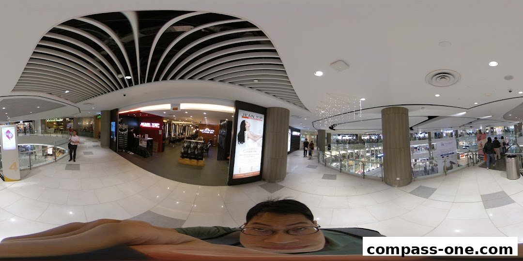 A panoramic view of a shopping mall with the Jean Yip salon visible.