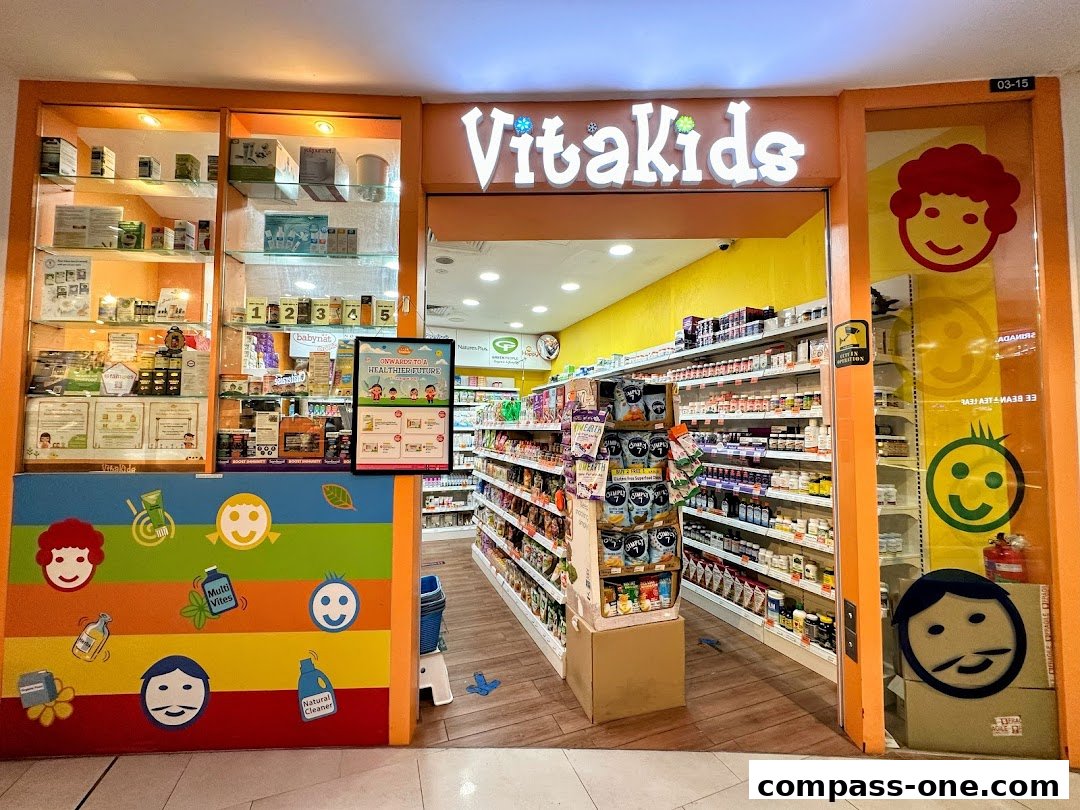 The entrance of VitaKids, a shop selling health products, with colorful displays and shelves stocked with items.