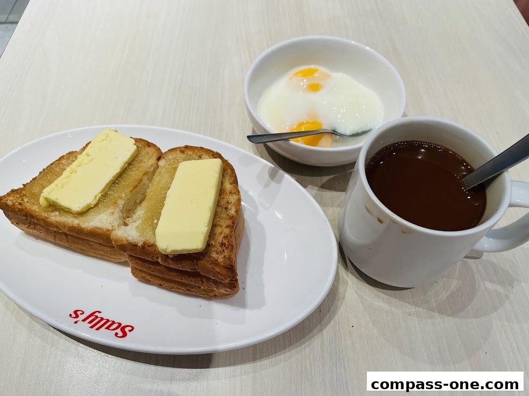 A delicious breakfast spread featuring buttered toast, soft-boiled eggs, and a hot cup of coffee.