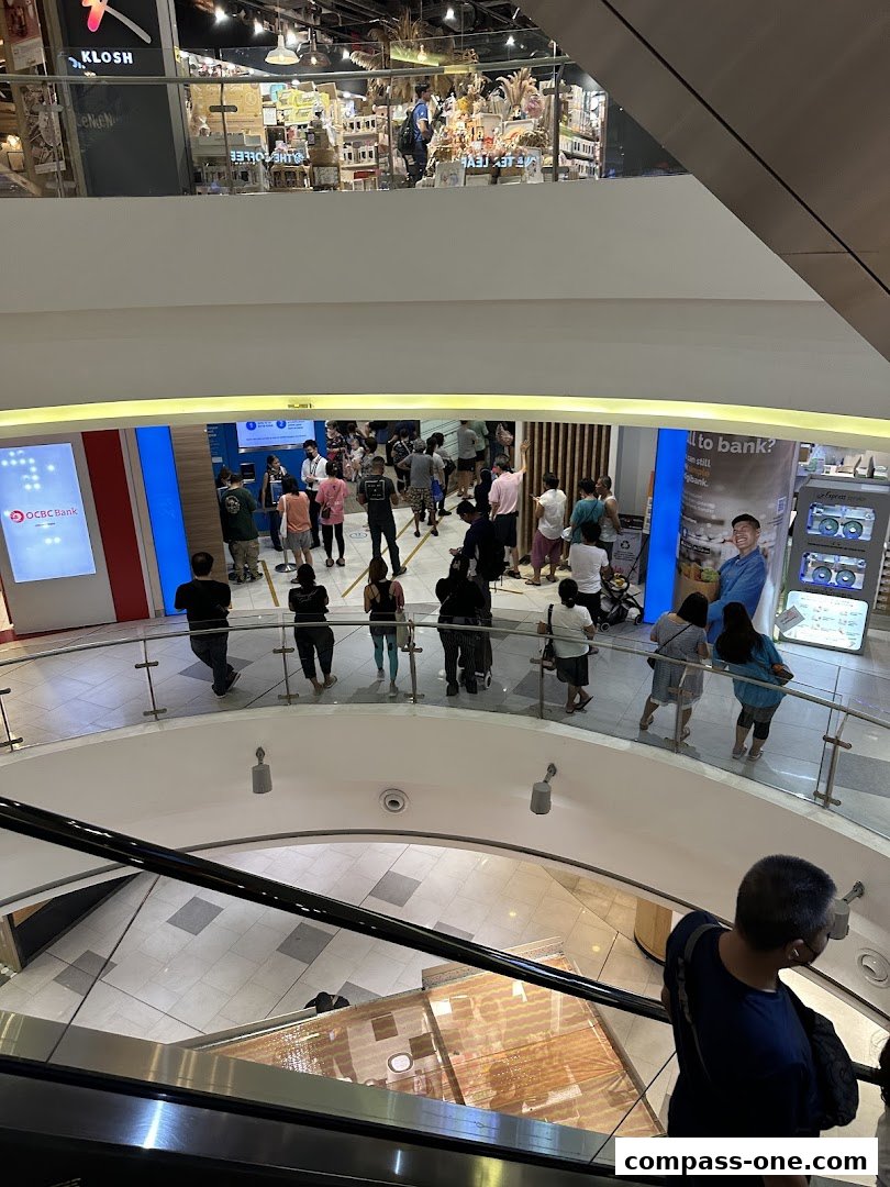 People queuing at a bank branch entrance on a mall level.
