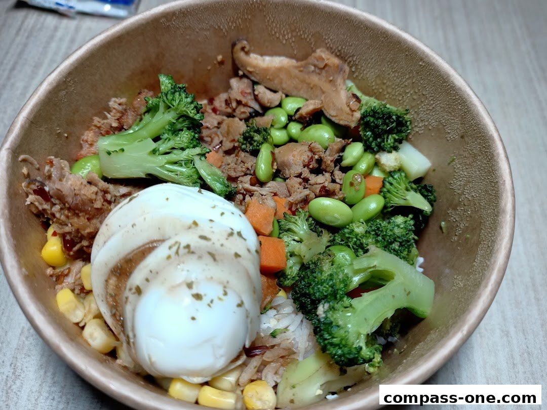 A close-up of a healthy and colorful poke bowl with rice, vegetables, and a soft-boiled egg.