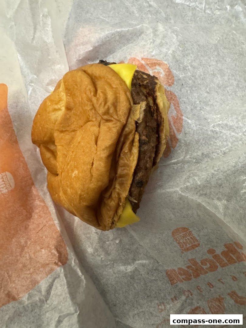 A close-up shot of a Burger King Whopper Jr. sandwich on white paper.