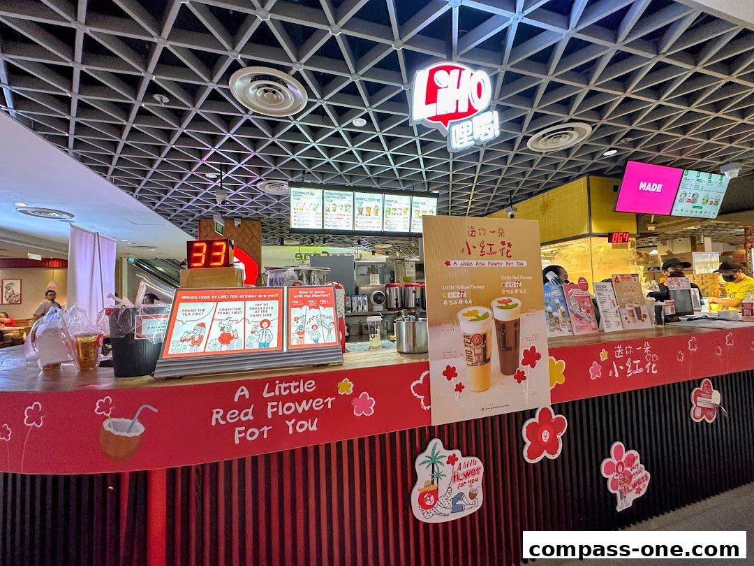 A LiHO TEA shop counter with promotional posters and a digital display showing '33'.