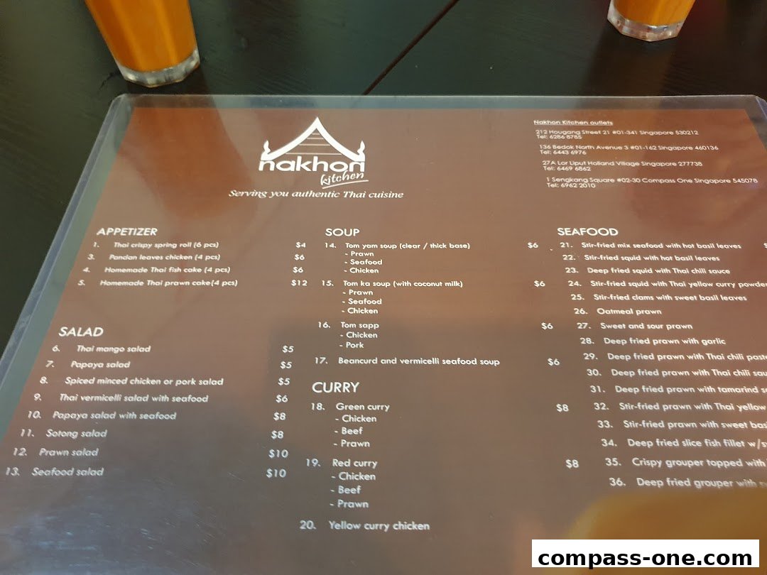 A menu from Nakhon Kitchen showing appetizers, salads, soups, seafood, and curry dishes with prices.