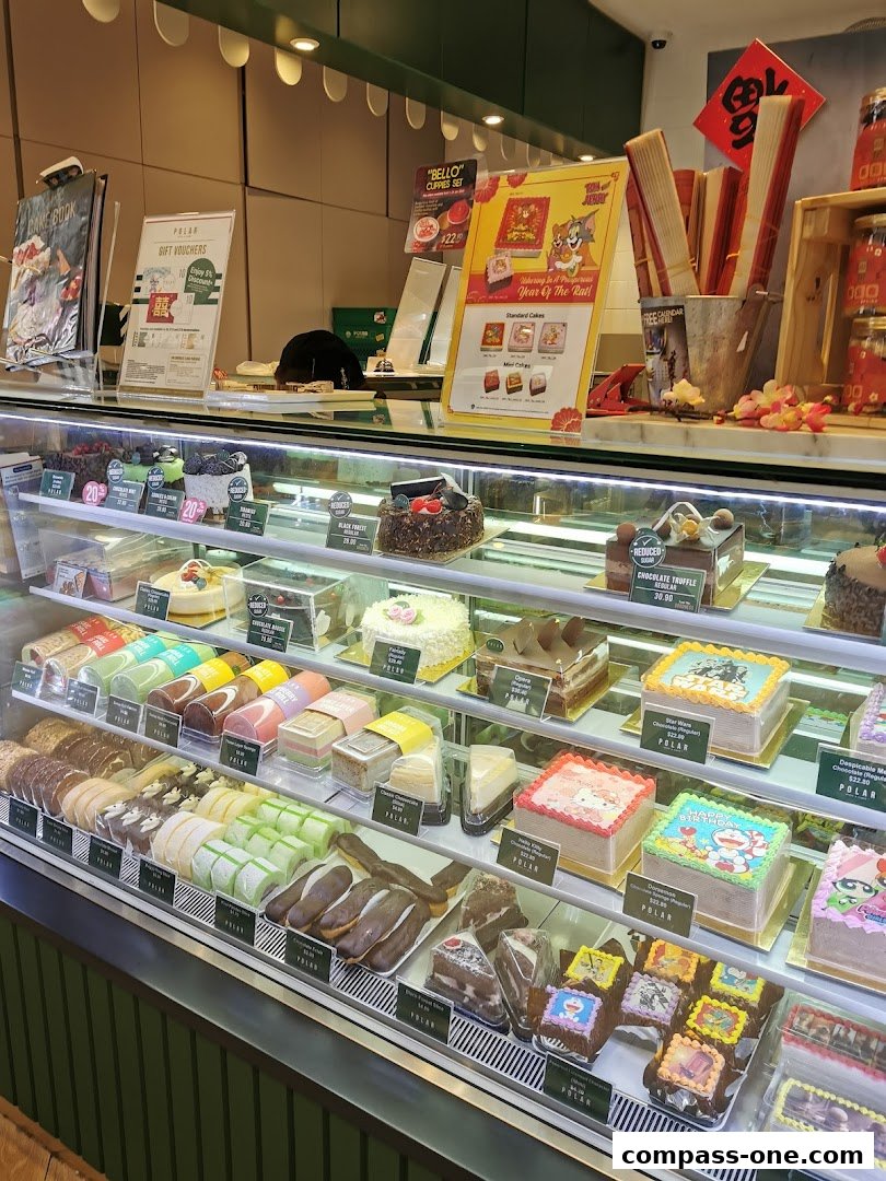 A display case filled with various cakes, pastries, and desserts at Polar Puffs & Cakes.