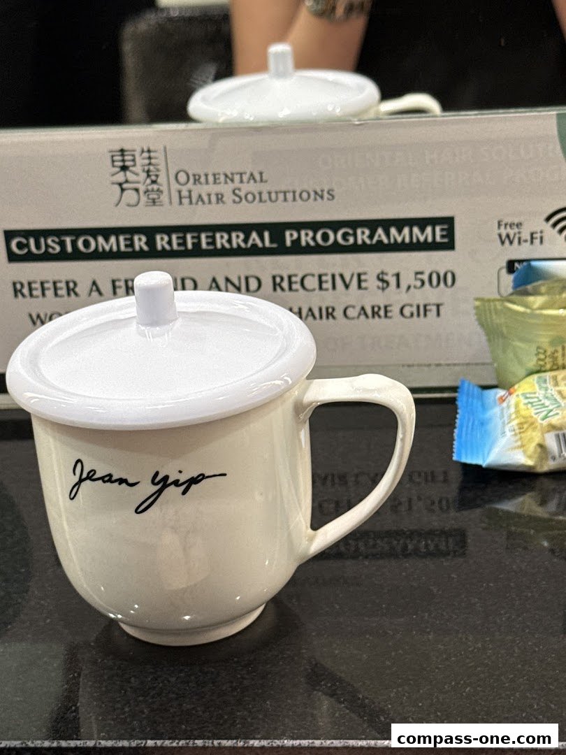 A mug with 'Jean yip' written on it, placed on a counter with shop branding in the background.