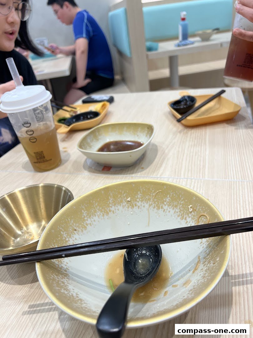 A table setting with partially eaten food, drinks, and chopsticks at Eat 3 Bowls.
