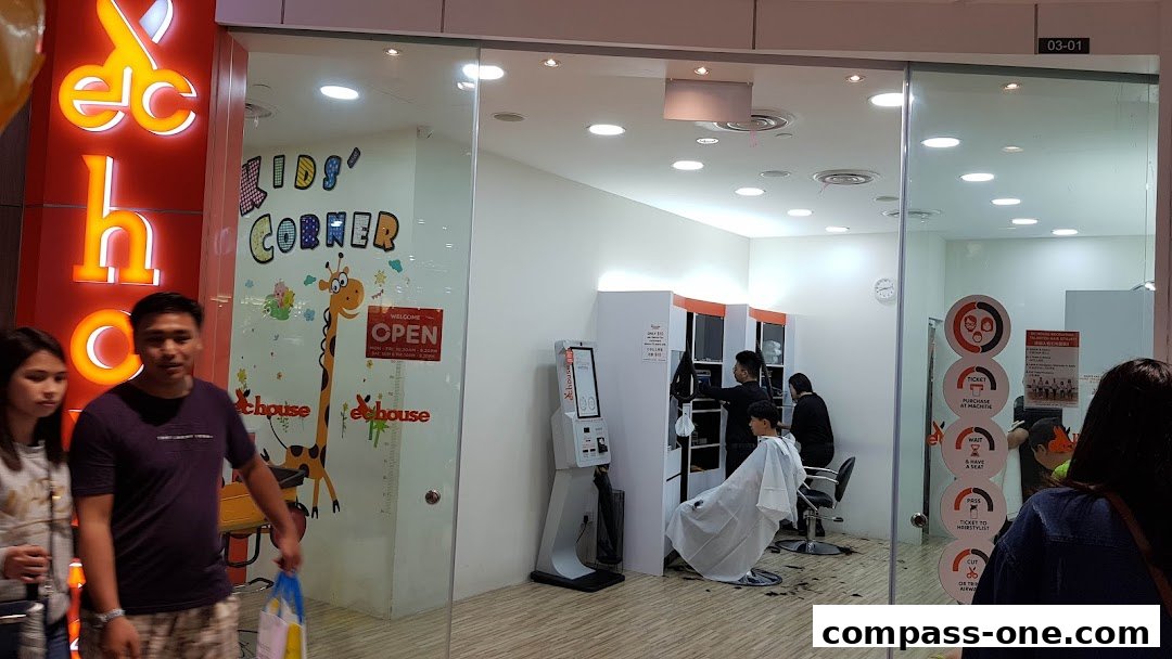 The exterior of EC House All Range Cuts, a hair salon with a kids' corner and visible stylists at work.