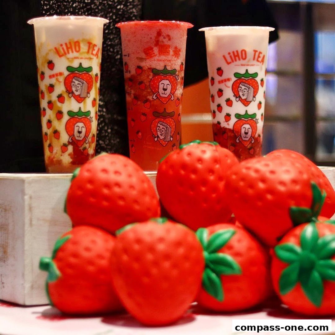 Three LiHO TEA drinks with strawberry-themed cups and decorative strawberries.