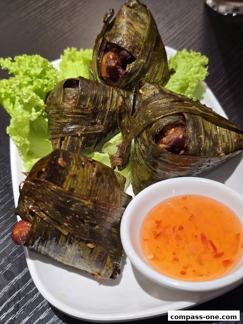 A plate of pandan chicken served with a side of sweet chili sauce and lettuce.