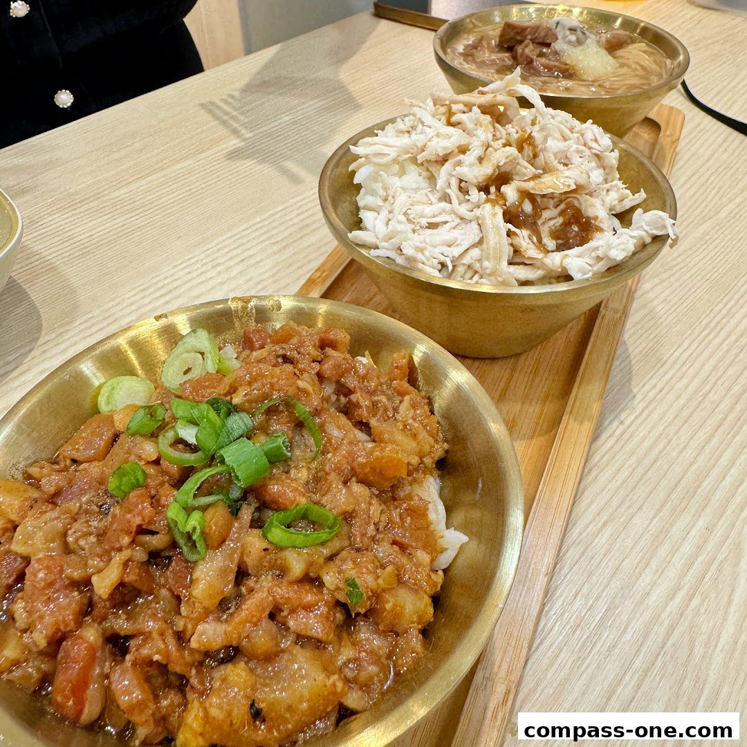 Three bowls of Taiwanese braised pork rice and shredded chicken rice are served on a wooden tray.