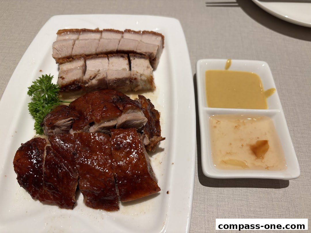 A platter of roasted duck and crispy pork belly with dipping sauces.
