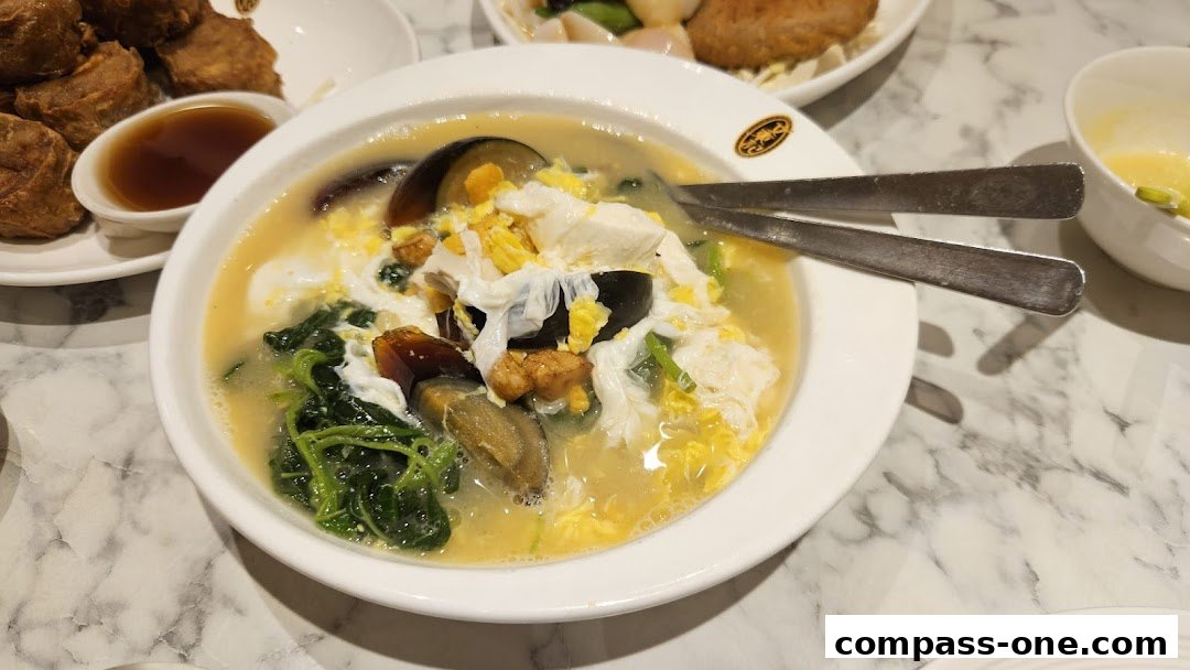 A close-up of a savory dish with egg, vegetables, and what appears to be preserved egg.