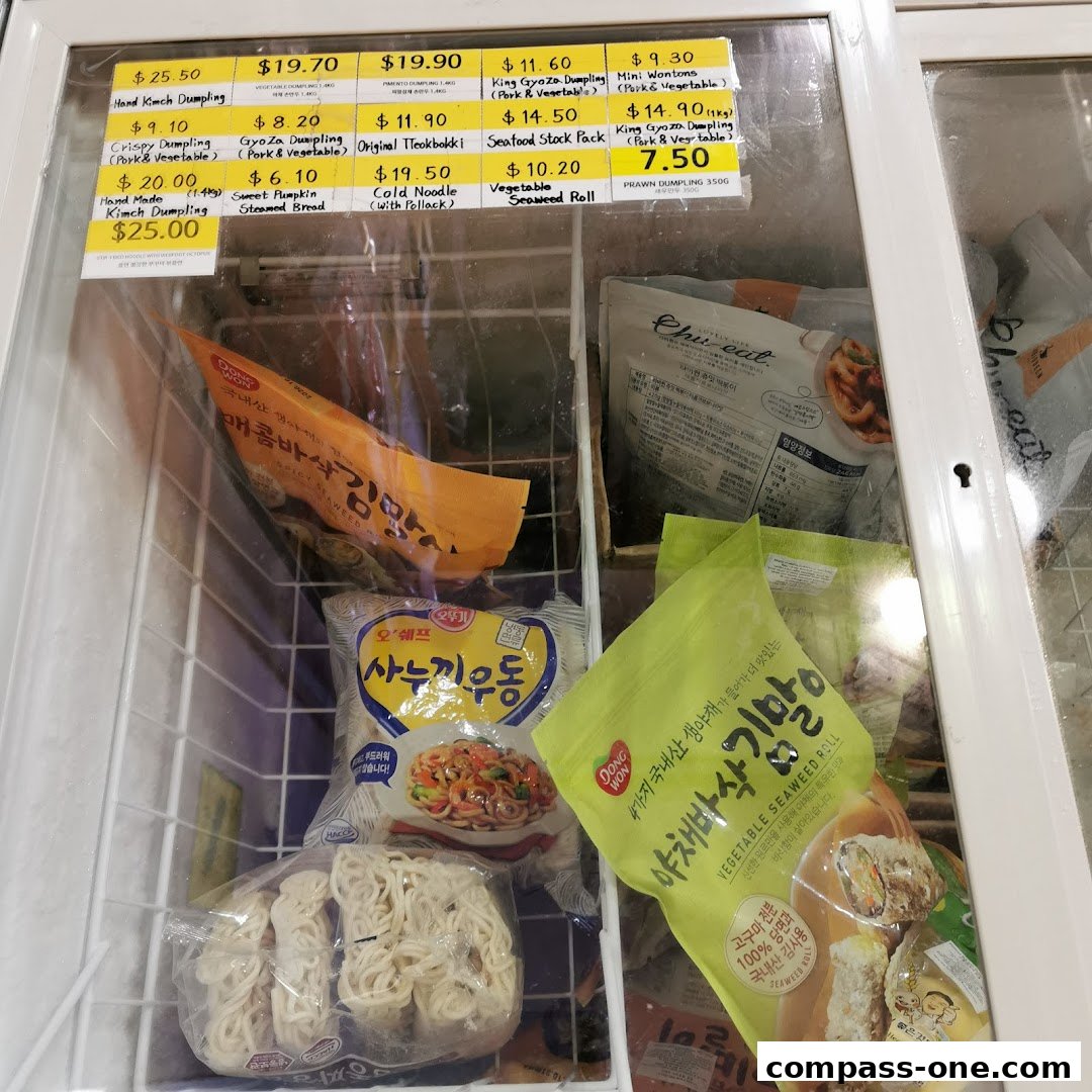 A freezer display case filled with various frozen Korean food items and their prices.