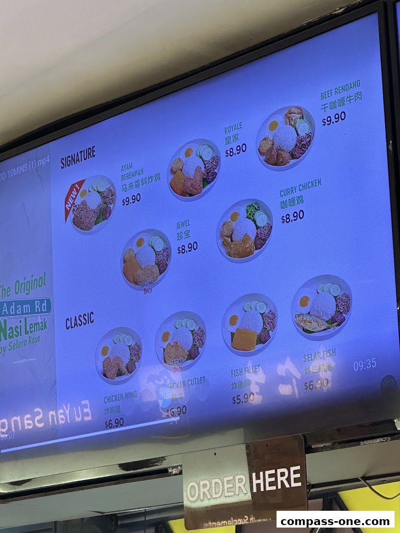 A digital menu board displaying various Nasi Lemak dishes with prices and images.