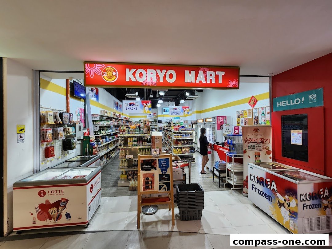 The entrance of Koryo Mart, a Korean convenience store, showcasing various Korean snacks and frozen goods.