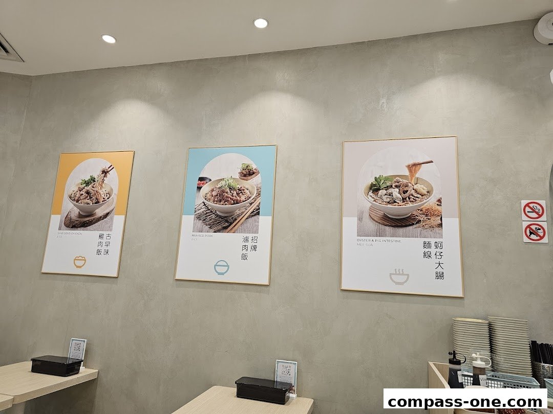 Three framed posters showcasing different noodle and rice dishes on a grey wall.