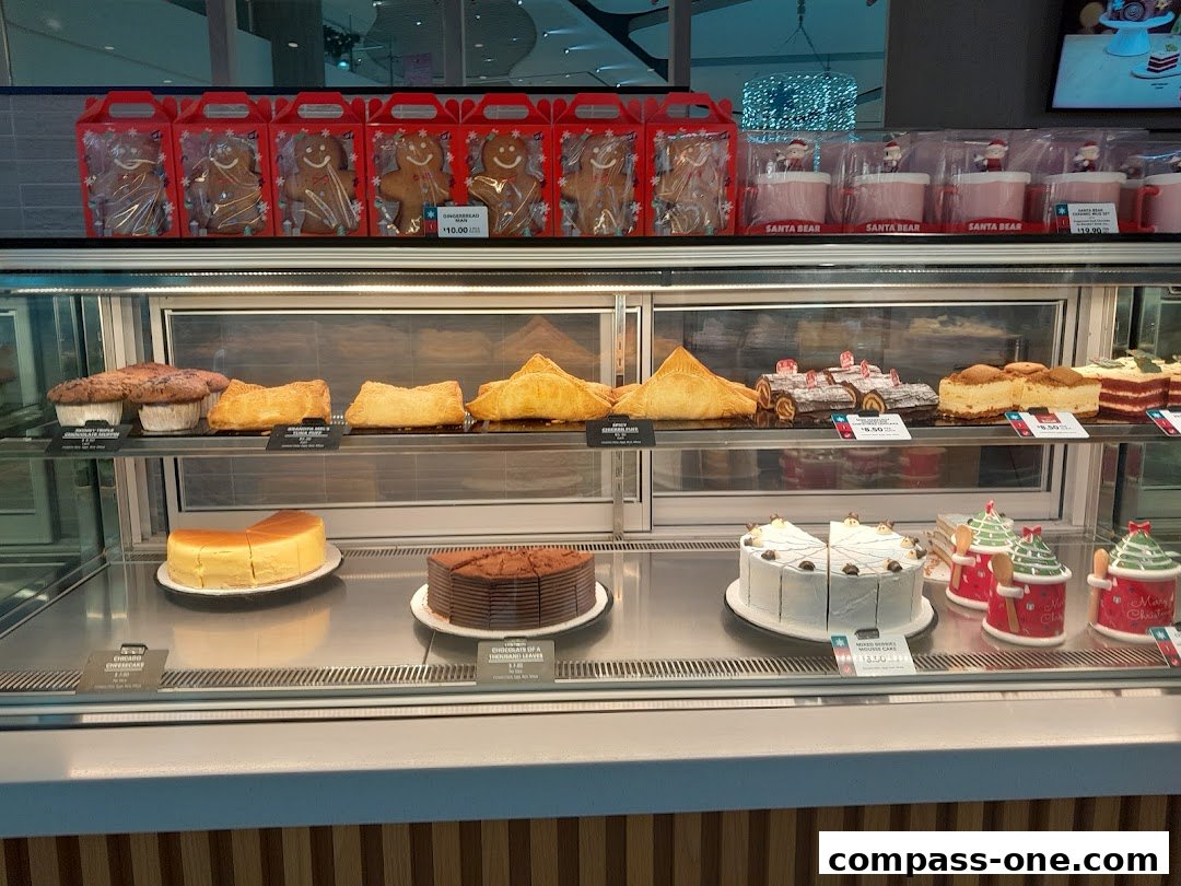 A display case filled with various festive holiday baked goods and mugs.