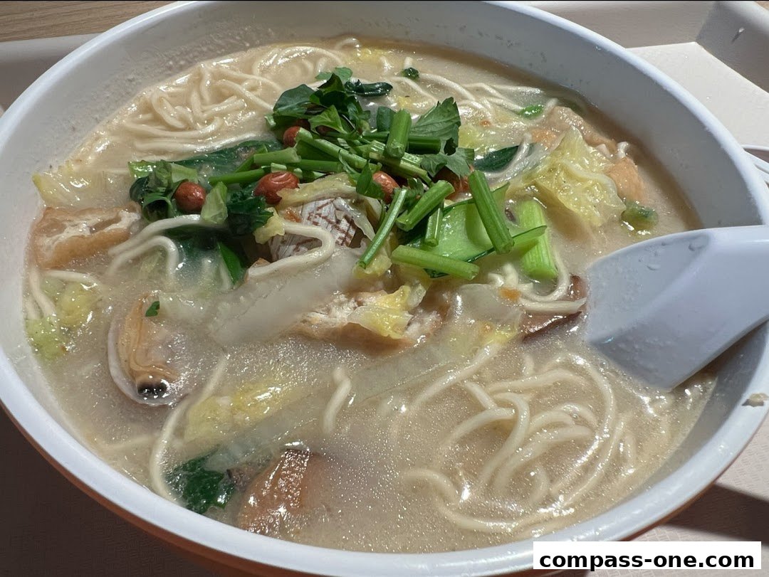 A close-up shot of a steaming bowl of noodle soup with various ingredients.