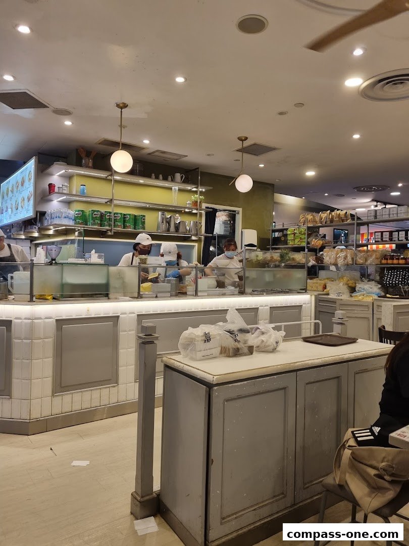 Interior view of a Toast Box cafe with staff preparing food behind a counter.