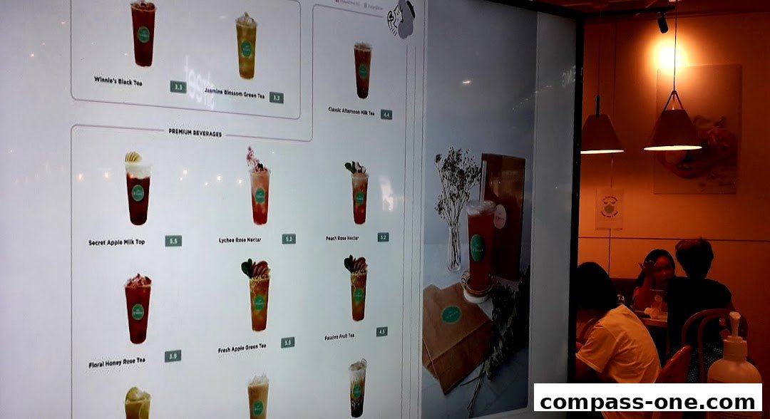 A digital menu board displaying various beverages with images and prices.