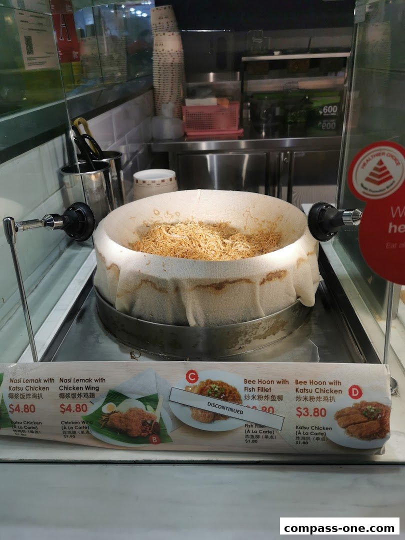 A display of food items with prices, featuring Nasi Lemak and Bee Hoon dishes.