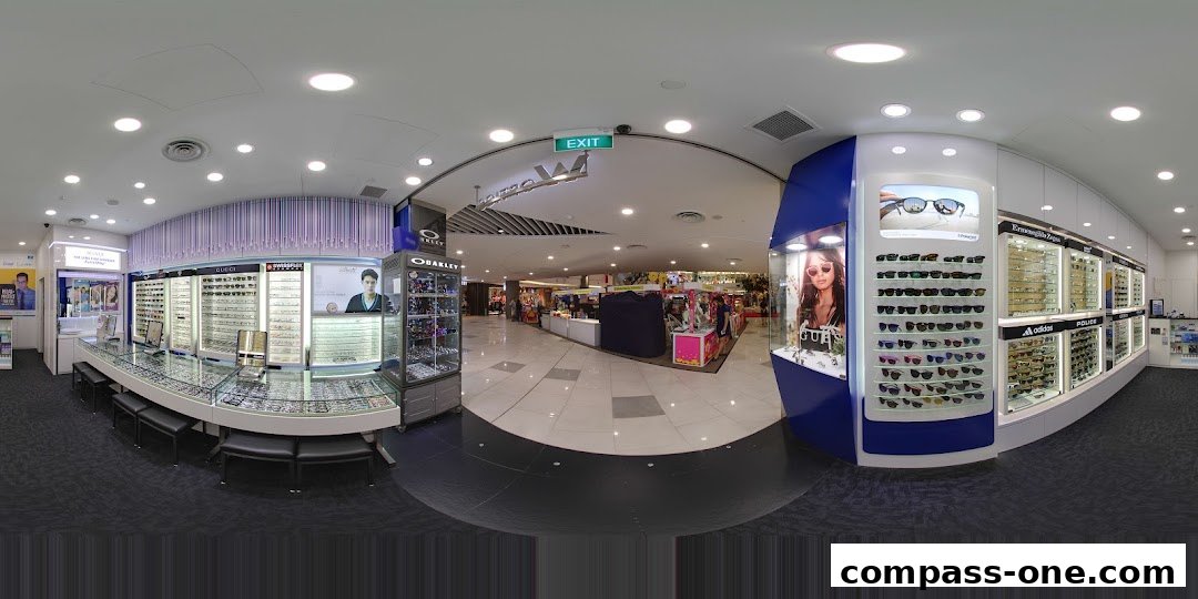 Interior view of an optical shop showcasing a wide selection of sunglasses and eyeglasses.
