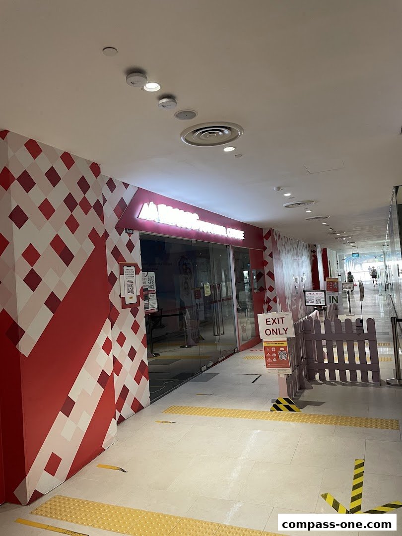 The entrance to Mavis Tutorial at Compass One, featuring a red and white patterned wall and glass doors.
