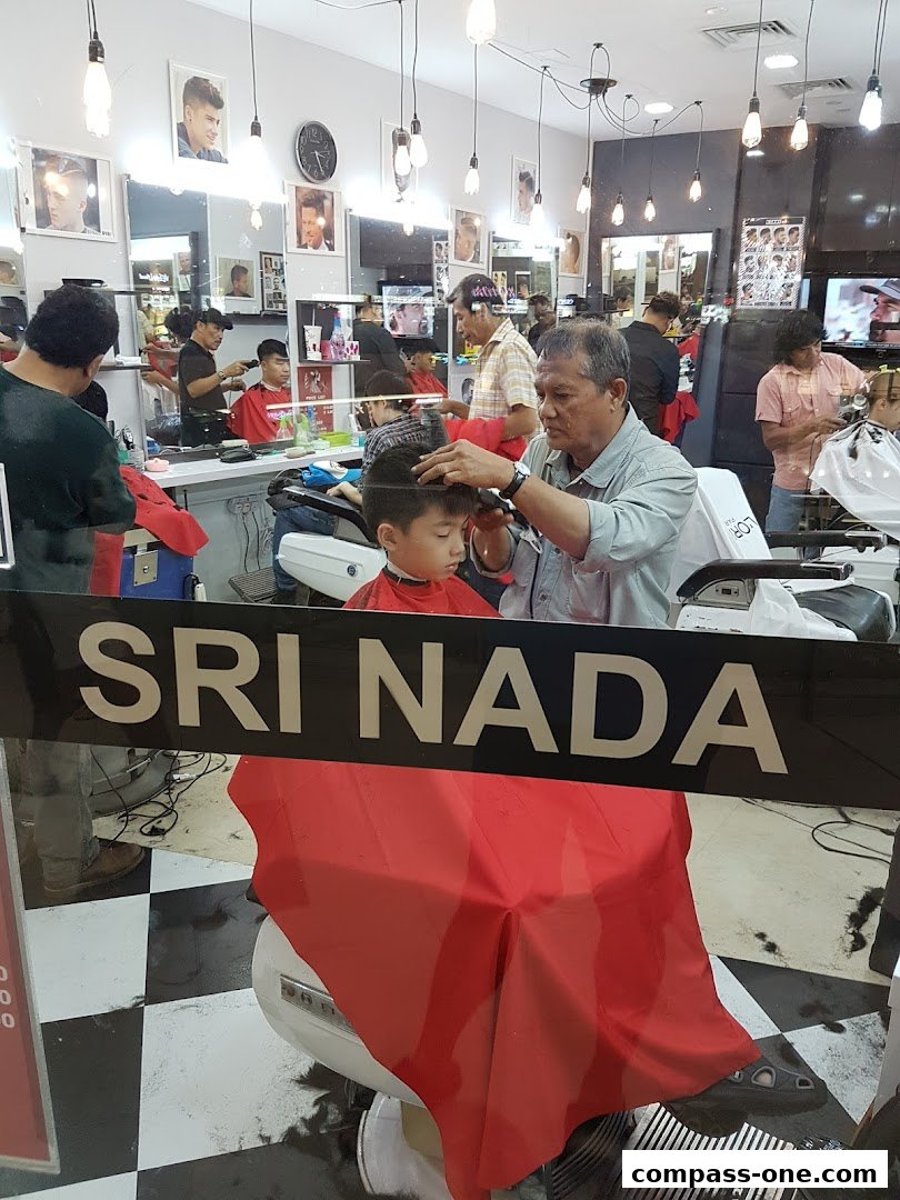 A barber is cutting a young boy's hair inside Sri Nada Hairdressing Salon.