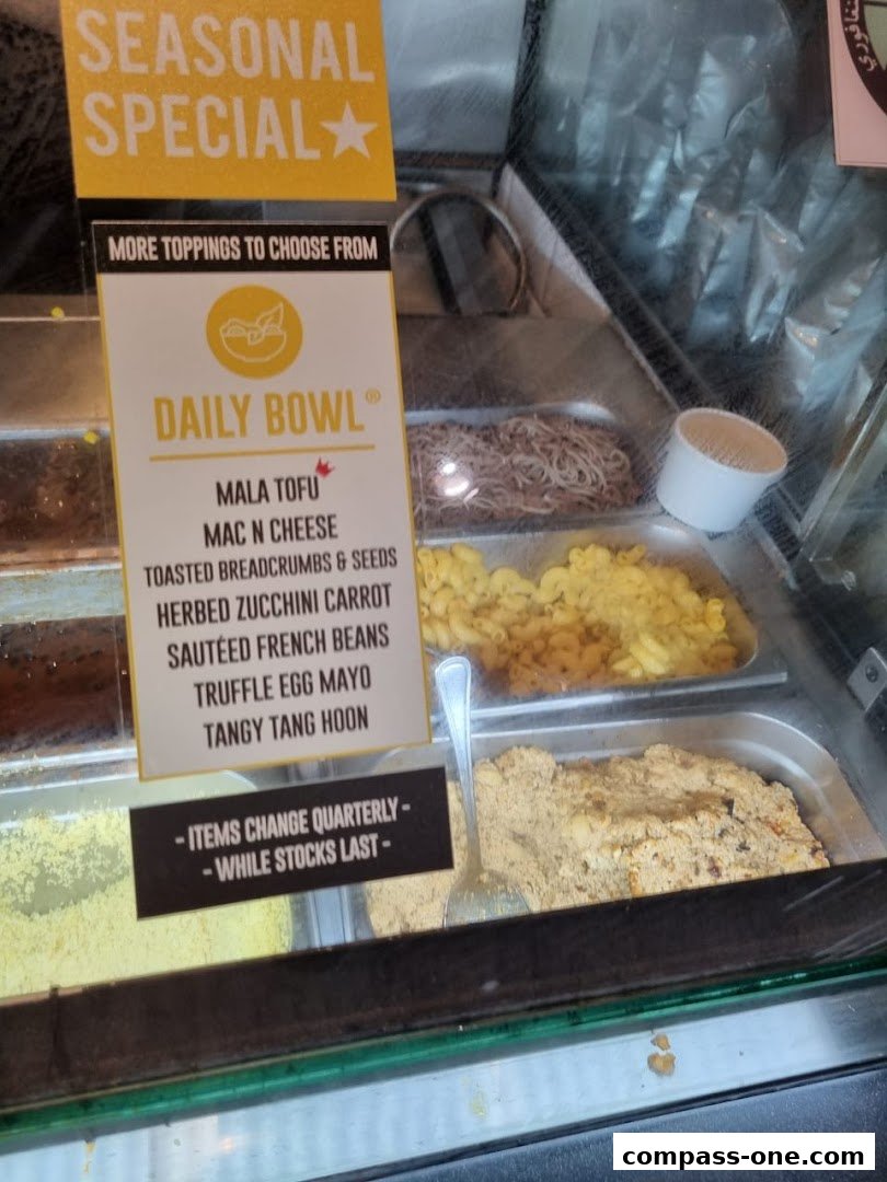 A display case showing ingredients for a 'Daily Bowl' with a seasonal special.