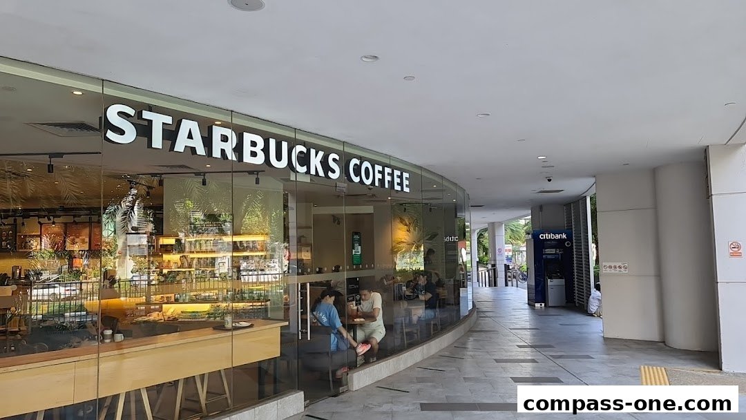 Exterior view of a Starbucks Coffee shop with customers inside and a Citibank ATM nearby.