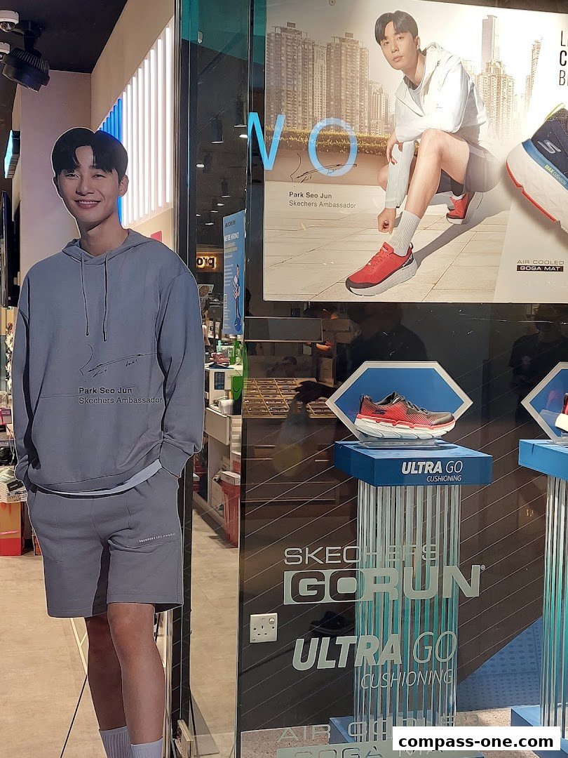 Skechers store window display featuring a cardboard cutout of ambassador Park Seo Jun and running shoes.